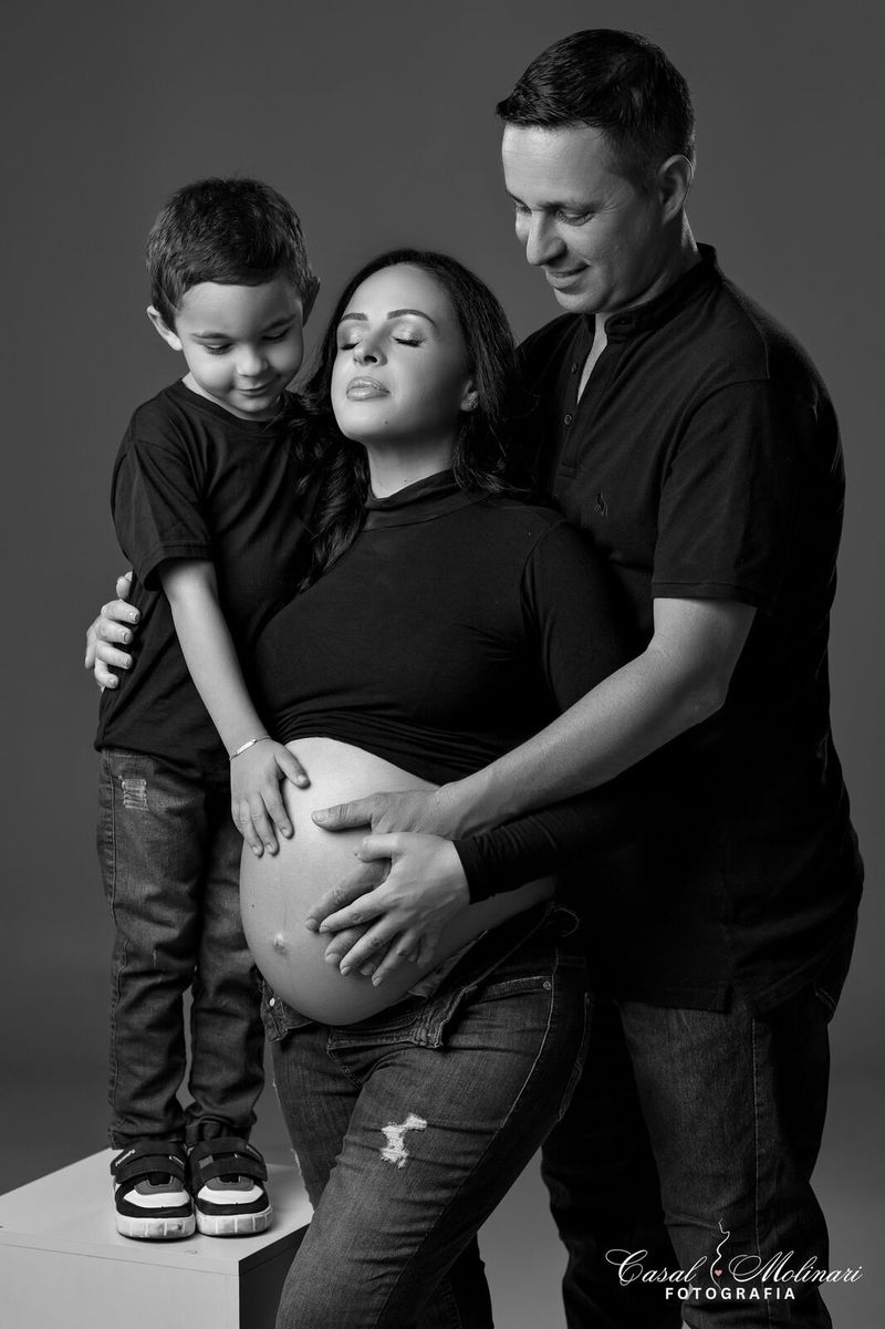 Família em preto e branco, com o filho junto à barriga