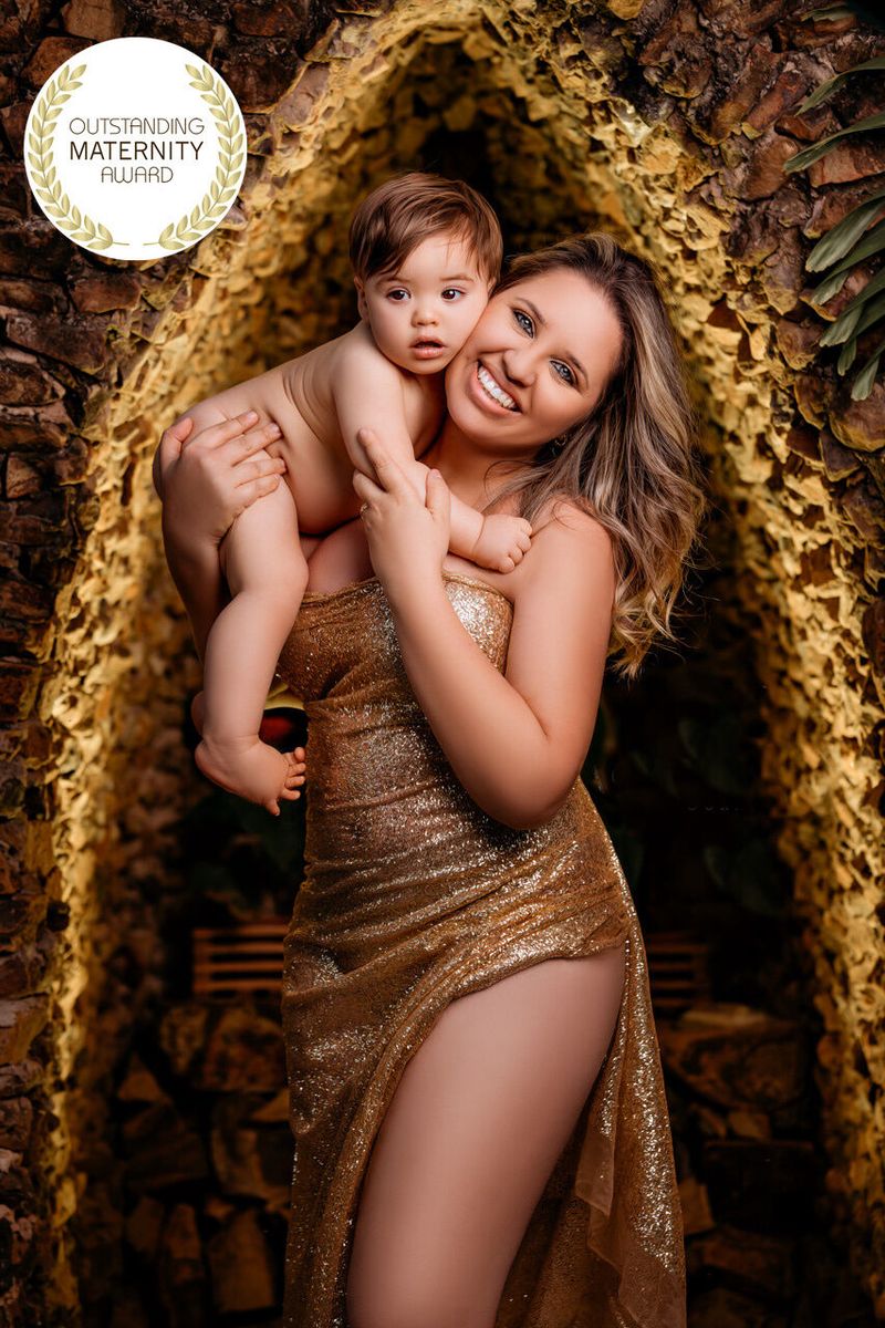 Mãe com o bebê no colo em produção dourada, foto premiada